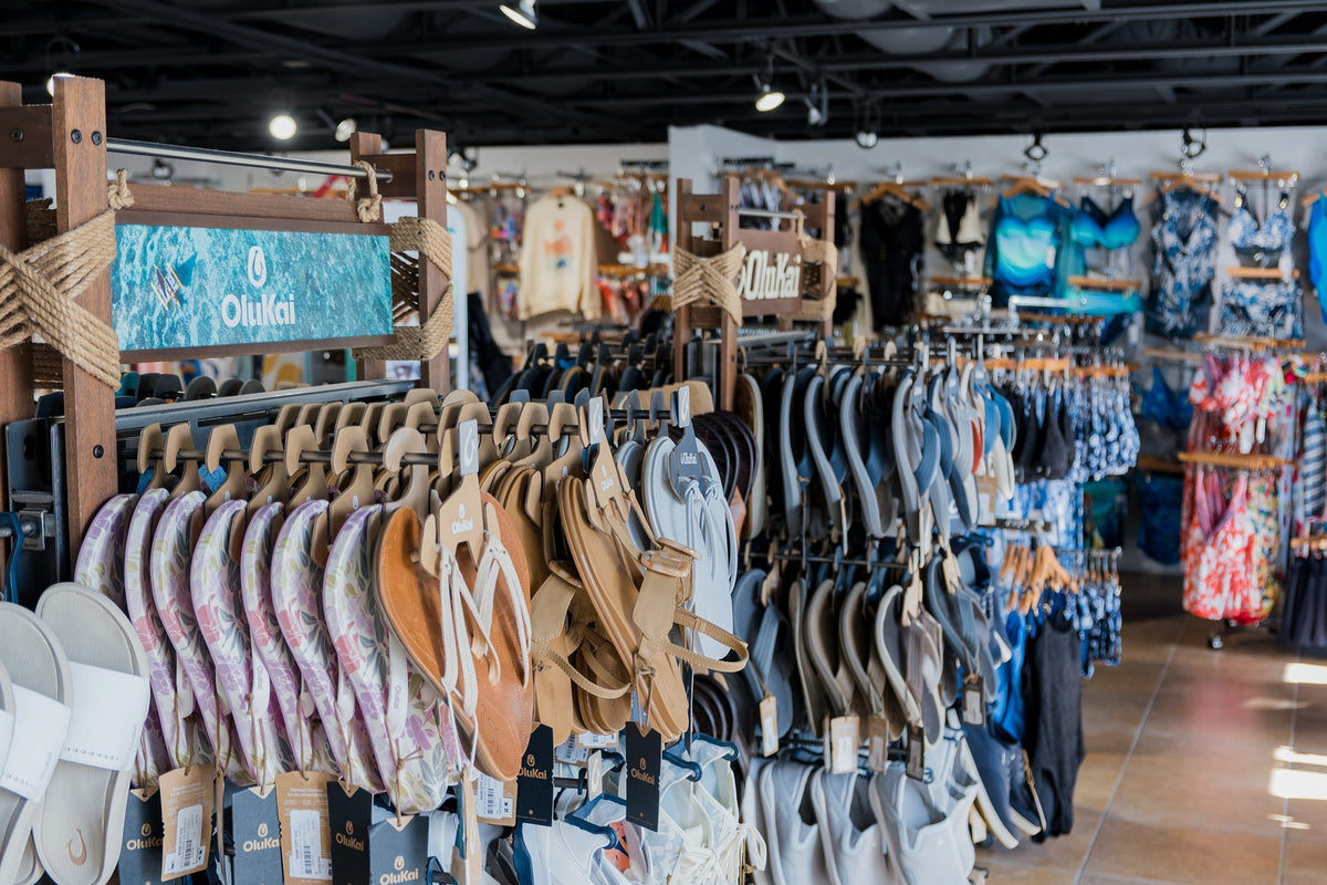 OluKai sandal display with branded signage at Swim City in downtown Sarasota